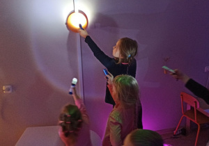 Dzieci świecą latarką na kolorowe koło