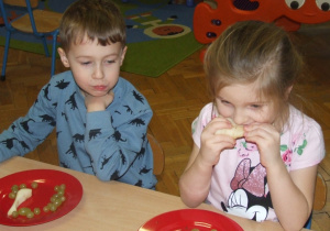 Dzieci jedzą owocowe jeżyki.