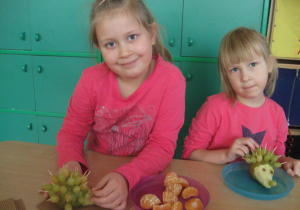 Dziewczynki wkładają winogrona na wykałaczki.