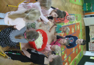 Dzieci wkładają kapustę do słoika.