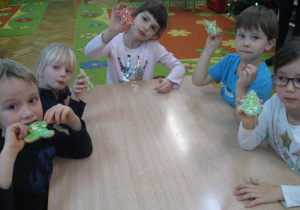 Dzieci jedzą wykonane ciasteczka.