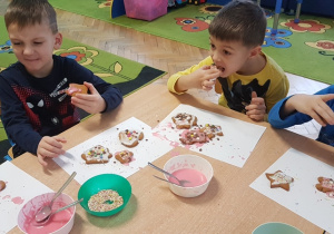 Dzieci zjadają wykonane przez siebie pierniki.