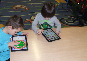 Chłopcy korzystają z aplikacji na tablecie.
