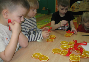 Dzieci ozdabiają suszone owoce.