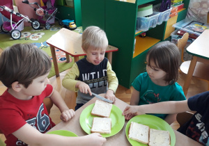 Dzieci smarują pieczywo masłem