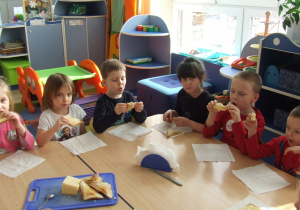 Dzieci jedzą tosty.