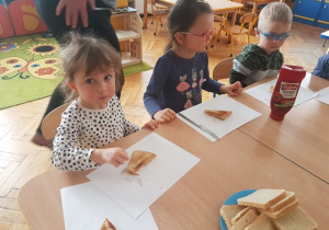 Dzieci jedzą upieczone tosty.