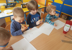 Dzieci jedzą upieczone tosty.