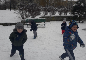 Dzieci biegają po parku.