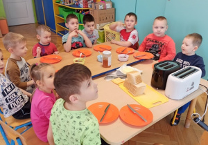 Dzieci słuchają zasad bezpiecznego korzystania z tostera
