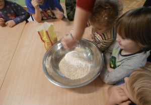 Chłopiec wsypuje do miski mąkę..