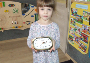 Dziewczynka prezentuje zegar.