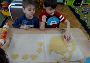 Chłopiec wykrawa ciasto foremką