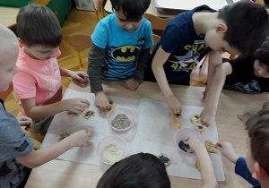 Dzieci posypują ciastka ziarnami