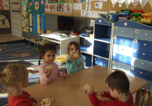 Dzieci pokazują upieczone ciasteczka.