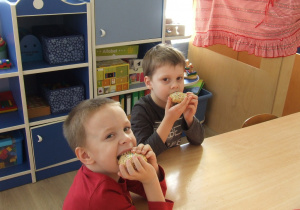 Dzieci jedzą upieczone ciasteczka.