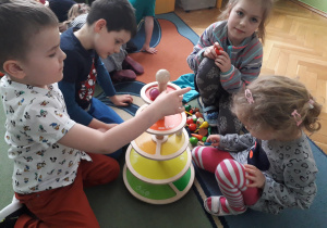 Dzieci w grupie układają produkty na swojej piramidzie zdrowia.