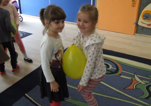 Dzieci tańczą w parach z balonikiem między brzuchami.