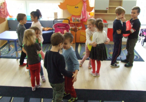 Dzieci tańczą w parach z balonikiem między brzuchami.