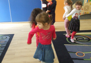 Dzieci tańczą w parach z balonikiem między plecami.