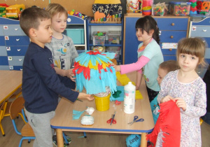 Dzieci przyklejają bibułę na balon.