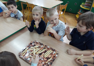 Dzieci jedzą paluszki grissini