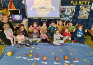 Dzieci prezentują wykonany z owoców Układ Słoneczny.