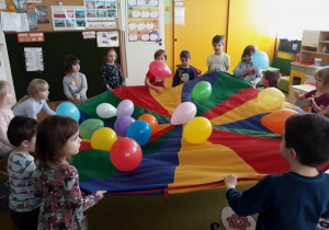 Dzieci bawią się balonami na chuście animacyjnej