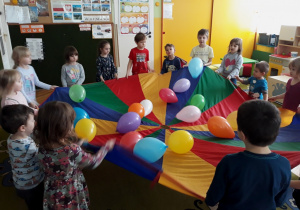 Dzieci bawią się balonami na chuście animacyjnej