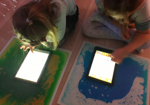 Dzieci grają w grę edukacyjną na tablecie.