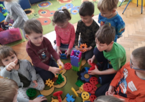 Dzieci wspólnie z klocków budują wieżę.