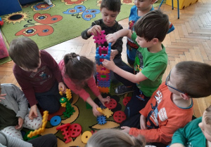 Dzieci wspólnie z klocków budują wieżę.