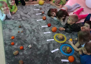 Dzieci układają planety z owoców i warzyw