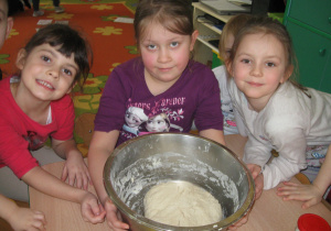 Dzieci wyrabiają ciasto do pizzy.
