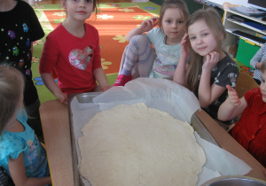 Dzieci rozkładają placek na pizze.