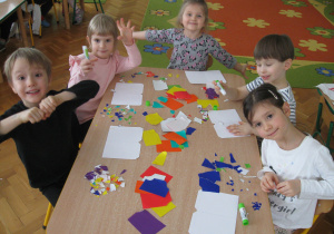 Dzieci wydzierają kolorowy papier.