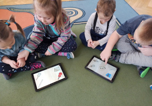 Dzieci korzystają z muzycznych aplikacji na tablecie.