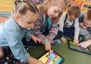 Dzieci korzystają z muzycznych aplikacji na tablecie.