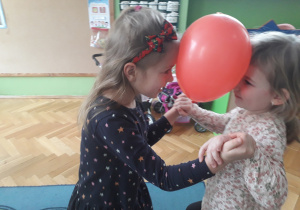 Dziewczynki tańczą z balonami.