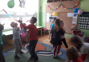 Dzieci odbijają balony do góry rękami.