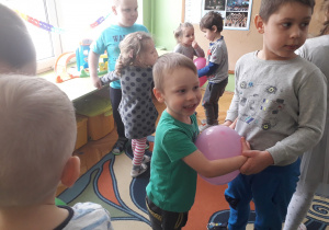 Chłopcy tańczą z balonami.
