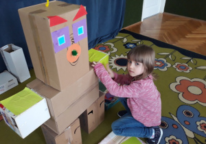 Dziewczynka okleja element robota