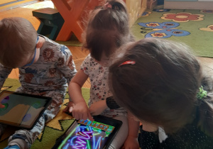 Dzieci grają w grę na tablecie.