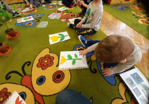 Dzieci układają puzzle rośliny.