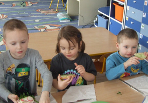 Dzieci jedzą przygotowane przez siebie kanapki.