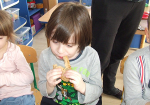 Chłopiec je chlebek.