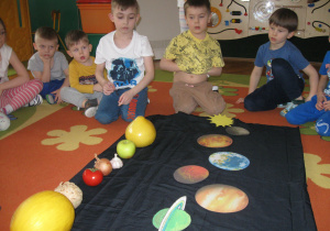 Dzieci dopasowują owoce i warzywa do planet w układzie słonecznym.