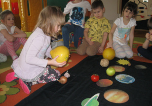 Dzieci dopasowują owoce i warzywa do planet w układzie słonecznym.