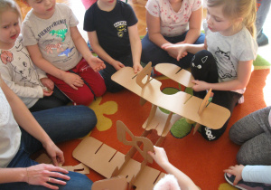 Dzieci składają model samolotu.