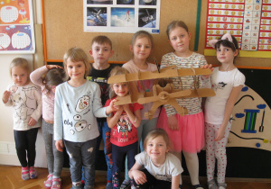 Dzieci prezentują złożony model samolotu.